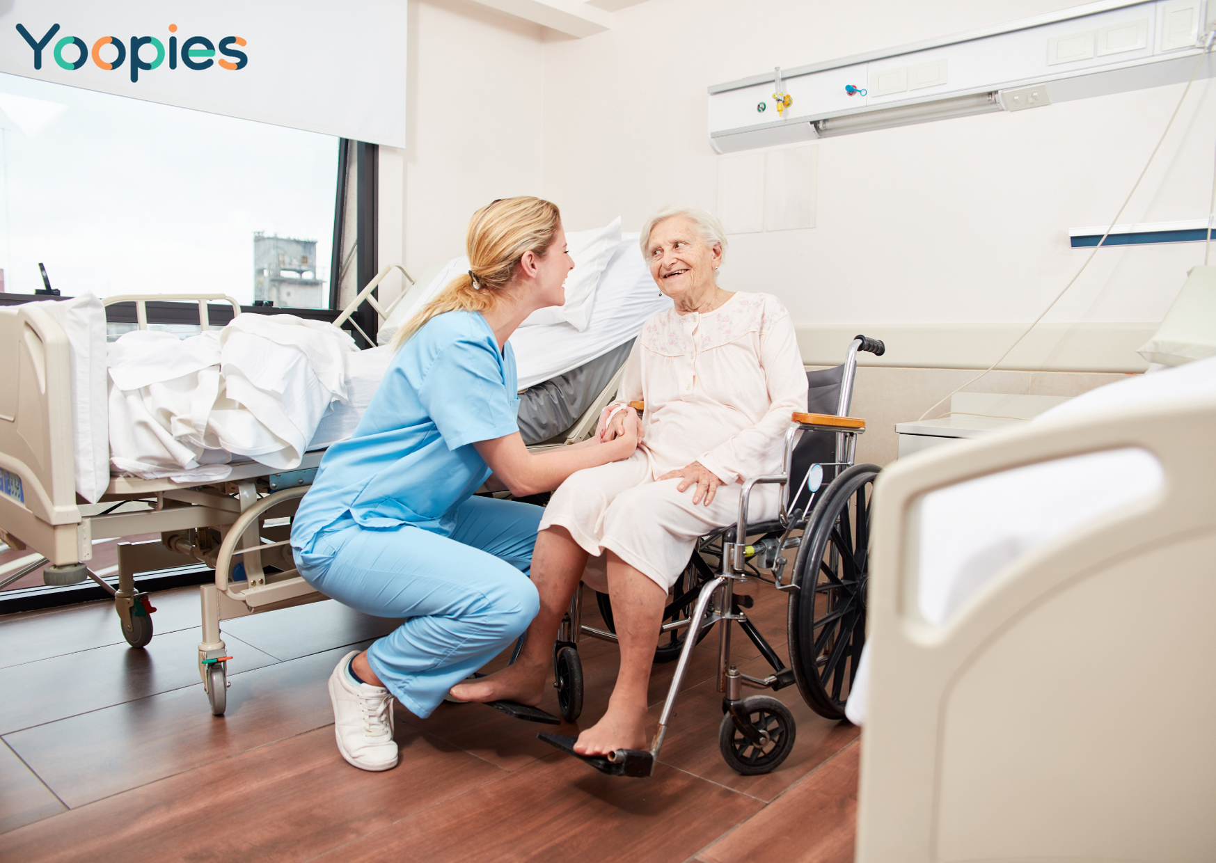 a care assistant talking to an elderly woman in a wheelchair